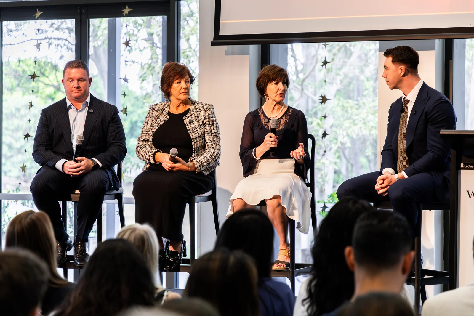Four panellists seated on stage in front of the audience.