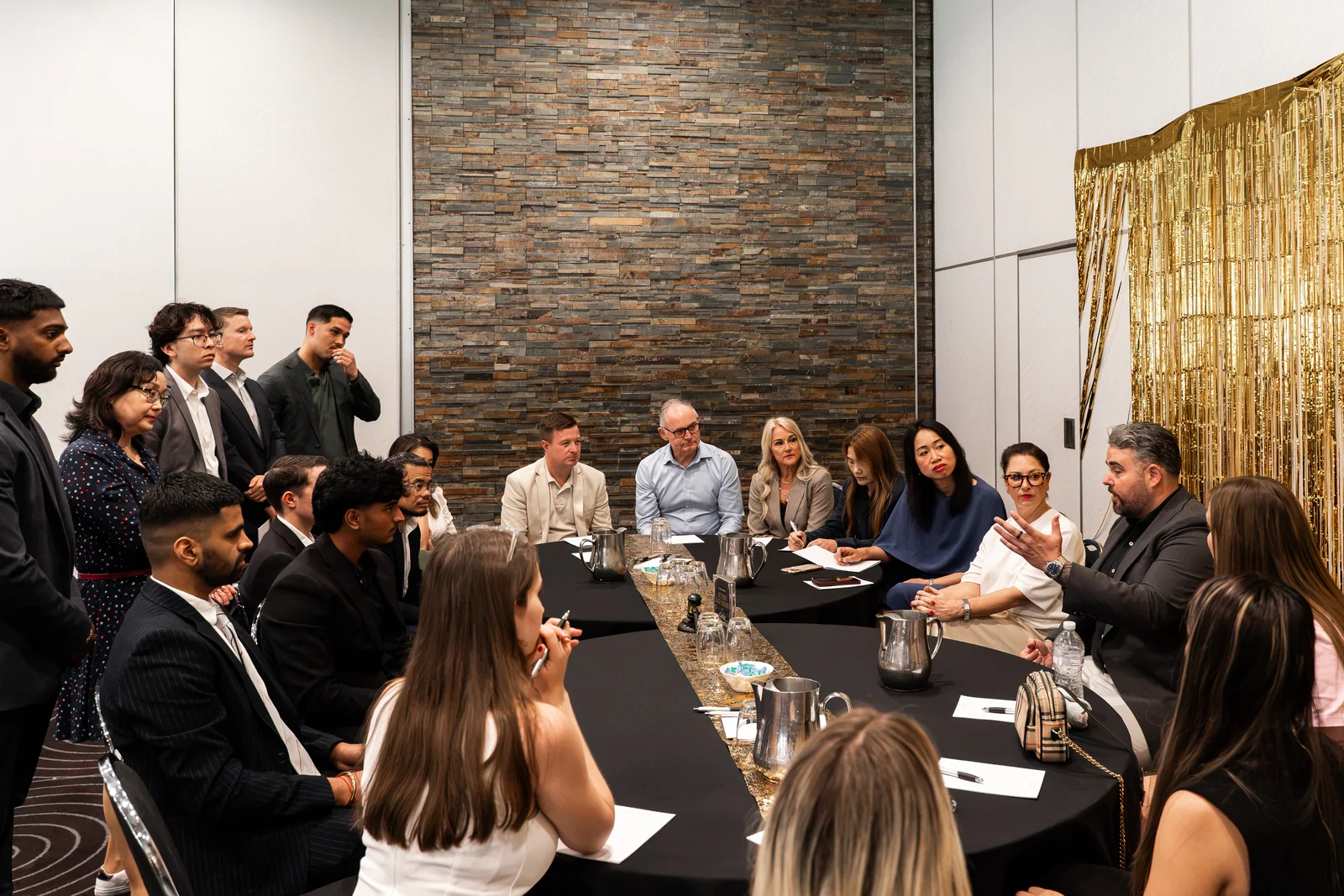Attendees exchange ideas around a conference table.