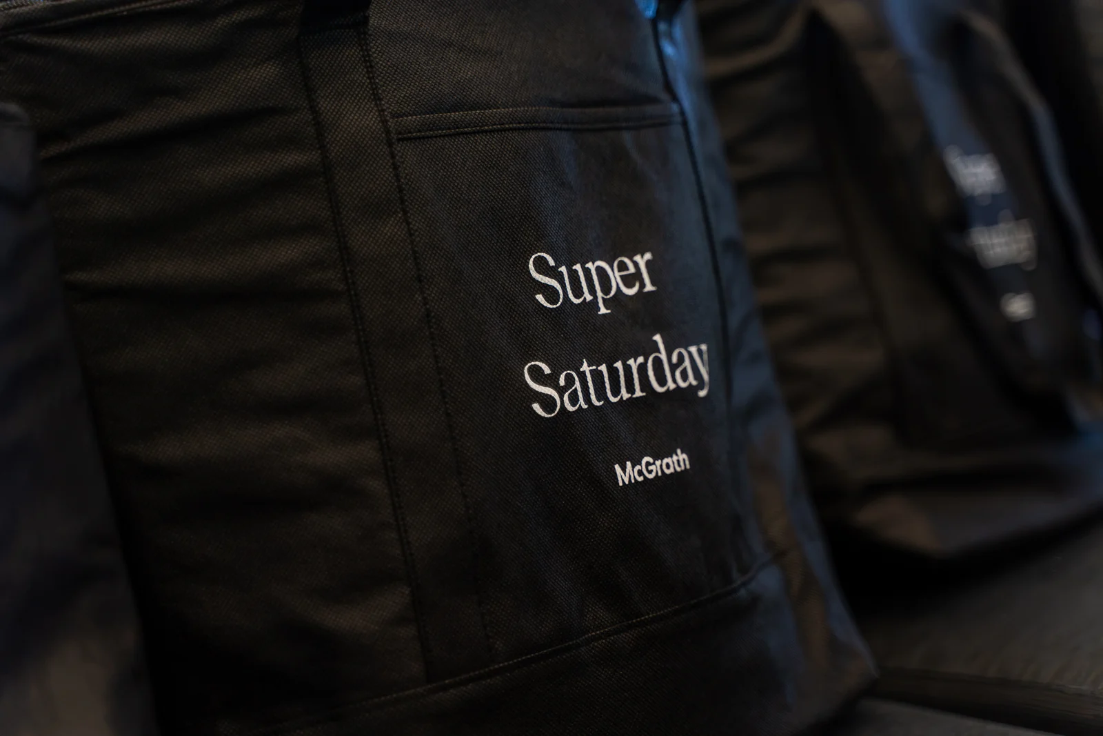 A close-up of a black Super Saturday event bag.